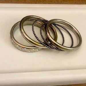 loose fitting bracelets. Silver band, rhinestone band, and rope twist like band